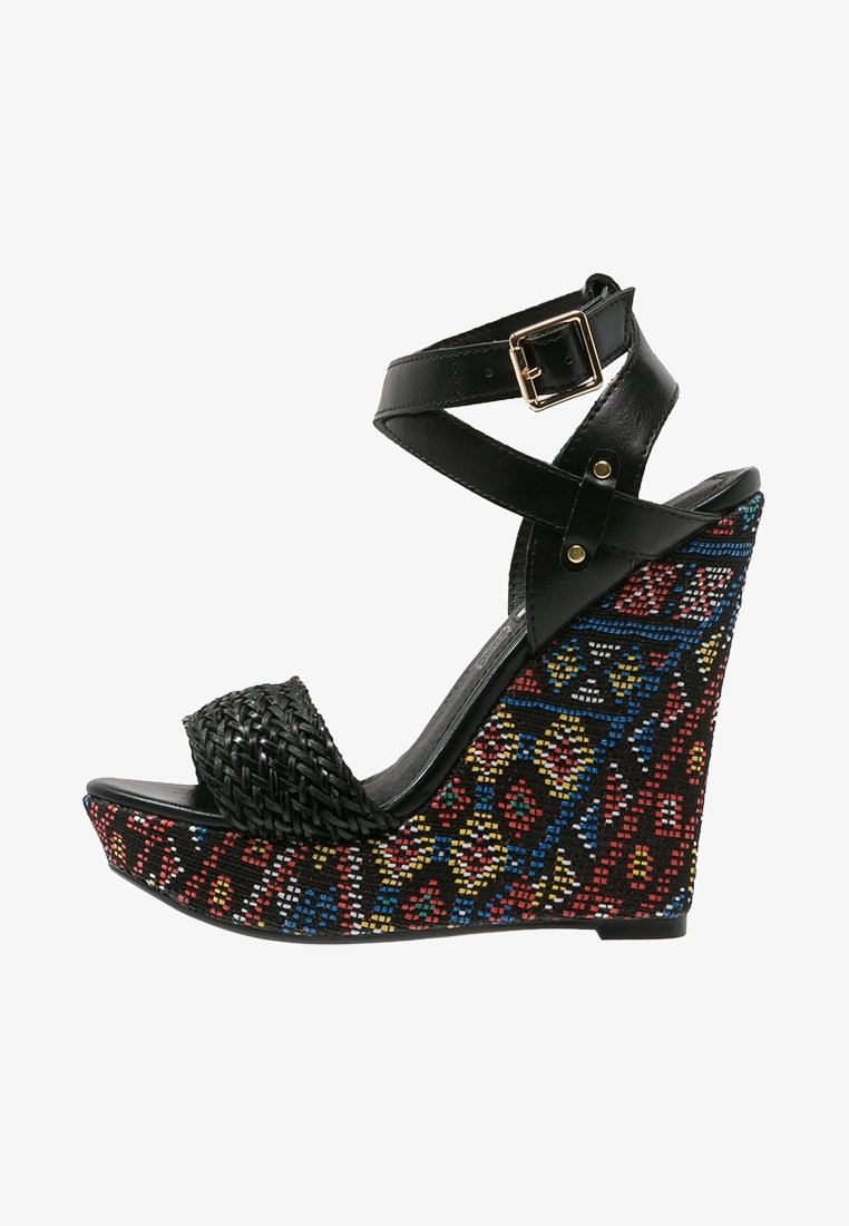 Sandale à talon compensé noire avec texture tressée sur la lanière avant et accents colorés à motifs sur la semelle compensée. Fermeture à boucle sur la lanière de la cheville.