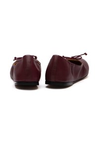 Bordeauxfarbene Leder-Ballettschuhe mit abgerundetem Zeh, weicher Textur und schwarzer Gummisohle. Mit Schnürung an der Ferse für eine verstellbare Passform.