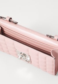 Rosa quilted lærveske med sølvfarget metallklips, glatt interiør, flere kortspor og delikate sømdetaljer.