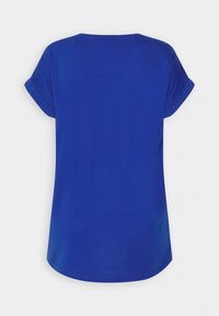 Camiseta azul real lisa de manga corta con puños enrollados y dobladillo redondeado, mostrada desde atrás sobre un fondo blanco.