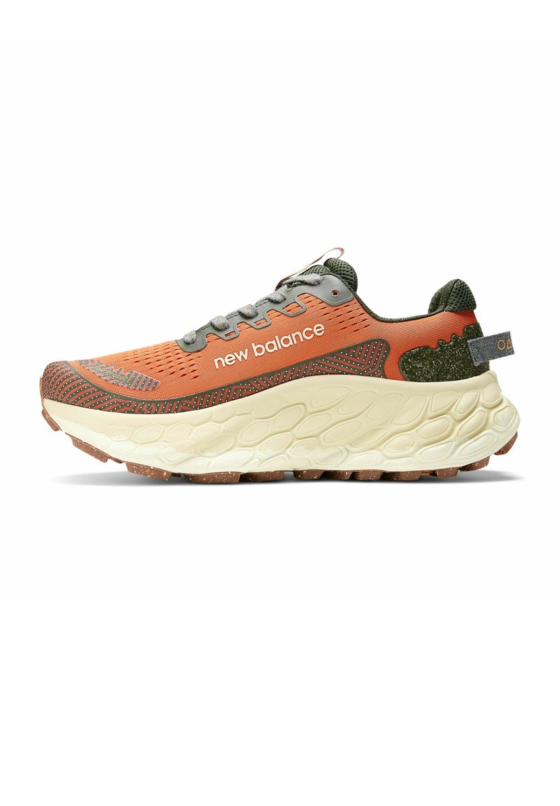 Zapatilla deportiva naranja y gris con parte superior texturizada, acentos verdes, suela gruesa color crema y la marca "new balance" en el costado.