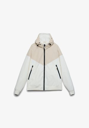 Giacca leggera con design a blocchi di colore beige e bianco, caratterizzata da cappuccio, tasche con cerniera e una texture liscia e opaca.