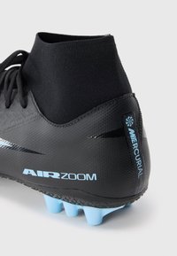 Crampon de football Nike Mercurial noir avec des crampons bleu clair et le texte "AIR ZOOM" sur le côté, dotée d'un col en chaussette montante.