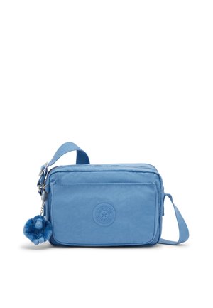 Pequeño bolso bandolera azul claro con bolsillo frontal, correa ajustable, parche redondo con logo y llavero azul con mono peludo.