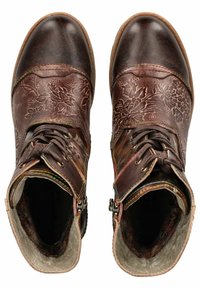 Botas de cuero marrón hasta el tobillo con grabados florales, superficie texturizada, costuras en contraste y cremalleras en los tobillos. Suelas planas.
