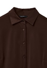 Dark brown collared shirt with button-down front, visible brand label "Calliope" in size small on the inside collar.