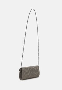 Bolso de mano en material plateado texturizado, de forma cilíndrica con una correa de cadena, que presenta sutiles patrones en forma de ola para un interés visual.