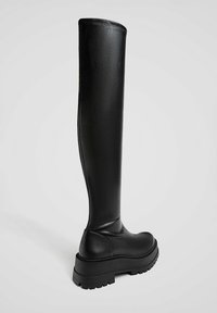 Czarne kozaki za kolano z gładkiej skóry, z grubą podeszwą, okrągłym noskiem i minimalistycznym designem. Szyte wykończenie u góry.