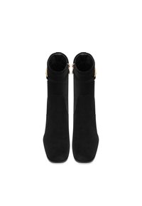 Stivaletti neri in suede con punta quadrata, dotati di zip laterale e dettagli in oro alla caviglia, con una superficie liscia.