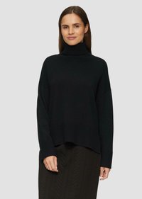 Schwarzer Rollkragenpullover mit lockerer Passform, gerippten Bündchen und Saum, der eine sanfte Textur aufweist; kombiniert mit einem dunklen, strukturierten Rock.