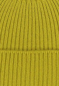 Berretto lavorato a maglia di un brillante giallo, caratterizzato da coste verticali e un risvolto, realizzato in morbido filato testurizzato.