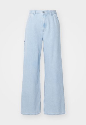 Jean large bleu clair en denim, comportant des poches avant, des passants de ceinture et une fermeture à bouton. Texture lisse et finition propre.