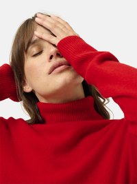 Rode geribde turtleneck trui met lange mouwen, met een zachte textuur en een aansluitende hals. Eenvoudig ontwerp, effen kleur.