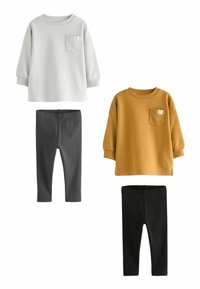 Twee hoodies, één lichtgrijs en één mosterdgeel, met zakdetails, gecombineerd met donkergrijze en zwarte leggings. Zacht katoenmateriaal.