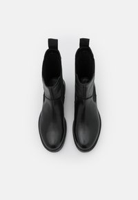 Bottes cheville en cuir noir à finition lisse, bout arrondi, panneaux élastiques sur les côtés et tirettes pour un enfilage facile.