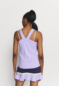 Fialový sportovní tank top s ramínky v designu racerback a kontrastní bílou látkou. Vrstvená sukně v námořnické modři se zeleným akcentem a volánkovým lemem.