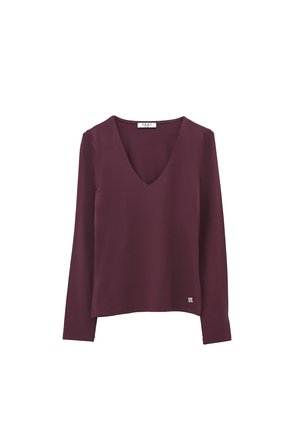 T-shirt à manches longues et décolleté en V profond pour femmes en couleur prune foncé avec une petite étiquette logo près de l'ourlet.