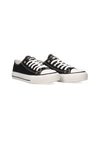 Zapatillas de lona negras con suelas de goma blanca, cordones blancos y costuras en contraste. Diseño tipo bajo con punta redonda y una suela texturizada.
