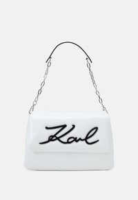 Borsa a tracolla bianca in ecopelle con logo "Karl" nero, dotata di tracolla in catena argentata e texture liscia. Forma rettangolare.