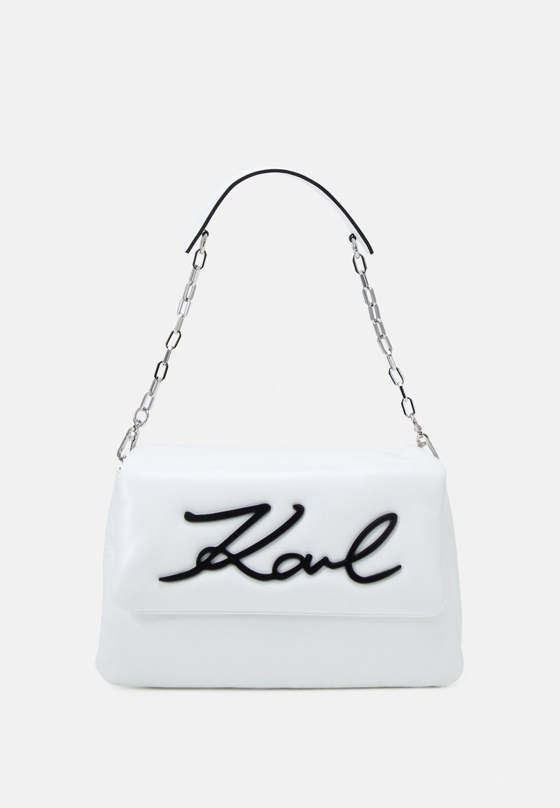 Borsa a tracolla bianca in ecopelle con logo "Karl" nero, dotata di tracolla in catena argentata e texture liscia. Forma rettangolare.