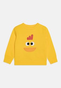 Yellow cotton sweatshirt featuring a playful character design with large black eyes and an orange mouth, complemented by a red crown detail.