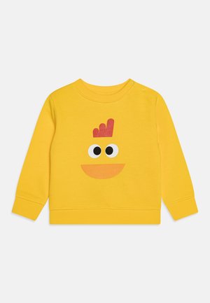 Geel katoenen sweatshirt met een speelse karakterontwerp met grote zwarte ogen en een oranje mond, aangevuld met een detail van een rode kroon.