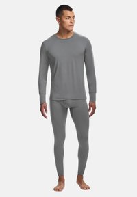 Graues langärmliges Oberteil und Leggings aus glattem, dehnbarem Material. Das Oberteil hat einen Rundhals; beide Teile haben eine enganliegende Silhouette.