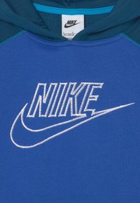 Nike blå hoodie med en stor broderad logotyp i vitt. designen har en jämn textur och är konstruerad med en kontrasterande teal halsringning.