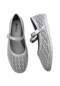 Zapatos estilo Mary Jane plateados con un patrón geométrico texturizado y una correa con hebilla. Fabricados con un material flexible y un interior suave.