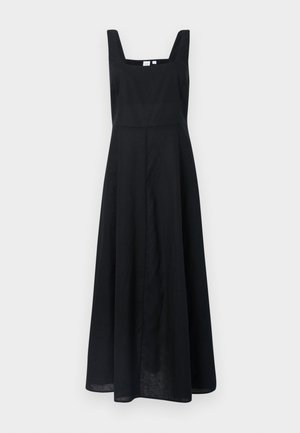 Robe en lin noire avec un décolleté carré, des bretelles larges et une jupe fluide qui atteint le mi-mollet. Design minimaliste sans motifs visibles.