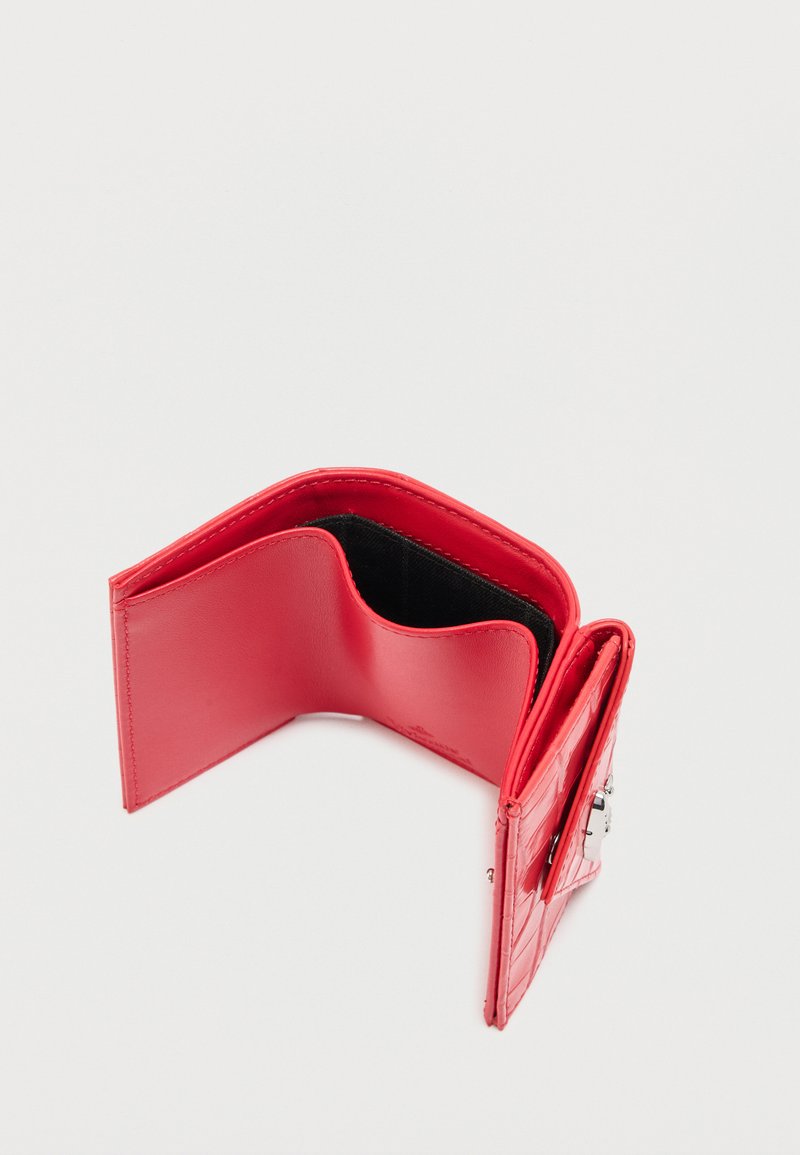 Rote Bi-Fold-Geldbörse mit strukturiertem Außenmaterial, geöffnet, um ein glattes Innenleben und ein kleines Münzfach mit Metallverschluss zu zeigen.