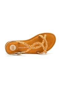 Sandal in pelle marrone chiaro con cinturini arancioni intrecciati che presentano piccoli accenti floreali. Soletta morbida con testo stampato, cuciture a contrasto e punta arrotondata.