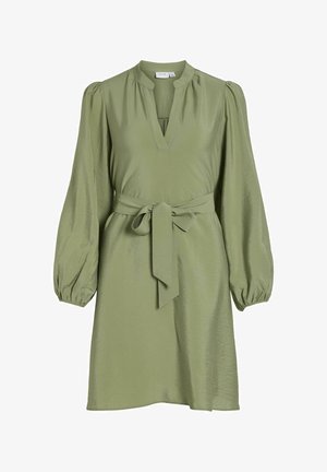 Olīvu zaļa kleita ar V veida kakla izgriezumu, garām pūkainām piedurknēm un auklas jostu uz vidukļa. Izgatavota no gludas, spīdīgas auduma ar brīvu piegriezumu.