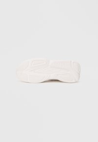 White sneaker sole with textured patterns and the brand name "HUGO" embossed on the heel area.