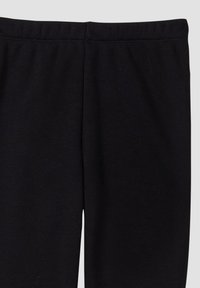 Zwarte leggings van een gladde, rekbare stof. De tailleband is elastisch voor comfort, met een schone, eenvoudige uitstraling. Geen zichtbare patronen of onderdelen.