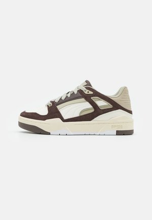 Sneaker low-top Puma in suede beige e marrone con dettagli in pelle bianca e suola testurizzata, stilizzati per un look casual.