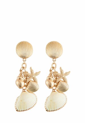 Des boucles d'oreilles en métal doré en forme de coquillage et d'étoile de mer, avec un stud en disque texturé, et des charms en cascade représentant des coquillages et des étoiles de mer de différentes formes et tailles.
