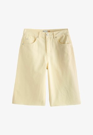 Világos bézs színű farmer rövidnadrág, öt zsebbel, cipzáras elülső résszel és gombos záródással, fehér háttéren laposan elrendezve.