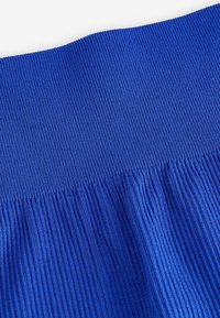 Blauwe ribbelstof met verticale strepen, met een gather-textuur aan de onderkant, wat een vloeiende uitstraling creëert.