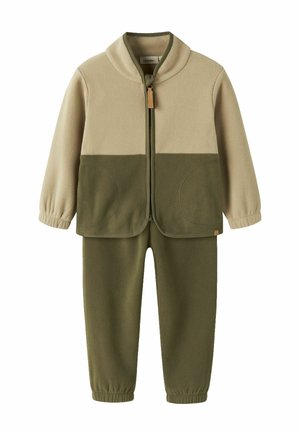 Ensemble polaire bicolore pour enfants avec veste supérieure beige et veste et pantalon inférieurs olive, fermeture éclair à l'avant, poignets élastiques sur les manches et les pantalons.