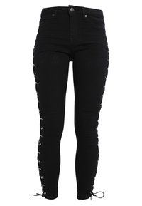 Black denim jeans with a high waist, lace-up sides featuring silver eyelets, and adjustable ties at the ankle for fit customization.