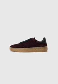 Baskets en daim bordeaux avec une tige texturée, lacets noirs et une épaisse semelle en caoutchouc gomme, présentant un design élégant et des accents minimalistes.