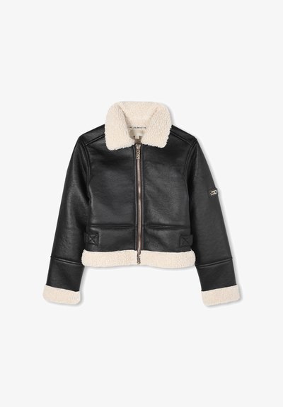 Juodas trumpas odinis švarkas su kremine avikailio apykakle ir apatine dalimi. Pasižymi priekiniais užtrauktukais ir šoninėmis detalėmis. Lygus tekstūra su figūrą galbūt akcentuojančiu dizainu.