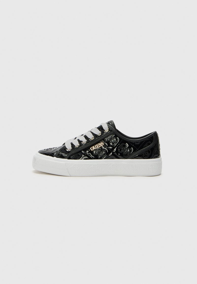 Svarta sneakers med en glänsande, texturerad yta med ett blommönster, vit sula och grå snörning. Gyllene "GUESS"-logotyp på sidan.