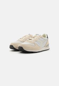 Beige and gray athletic shoes made of mesh and suede. Features a rounded toe, lace-up closure, and textured black rubber sole.