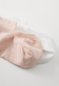 Gaiši rozā un baltu zeķu pāris, izgatavots no mīksta kokvilnas maisījuma. Iezīmējas ar vienkāršu dizainu, elastīgu augšpusi un bez redzamām rakstiem.