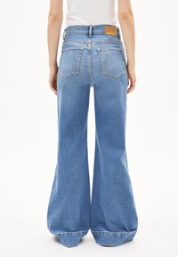 Lichtblauwe, uitlopende spijkerbroek met een hoge taille, knoopsluiting en achterzakken. Voorzien van een leren label op de tailleband.