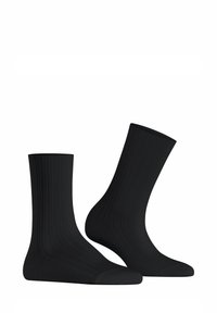 Ein Paar schlichte schwarze gerippte Crew-Socken, die vor einem weißen Hintergrund präsentiert werden. Eine Socke steht aufrecht, die andere ist zur Seite geneigt.