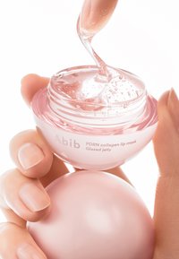 Masque pour les lèvres au collagène Abib PDRN dans un récipient rond et transparent avec des accents roses. Contient une substance translucide et gélatineuse avec des bulles.