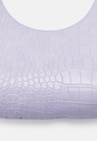 Ljus lavendelfärgad handväska med ett strukturerat krokodilsmönster, slät läderfinish och synlig sömnad längs kanten.